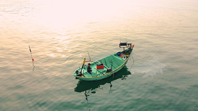 釣り人がルアーを手に持ち、水辺を見つめている様子