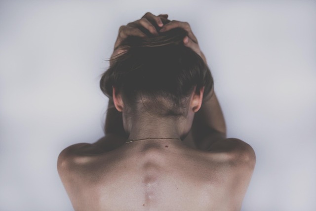 胃のむかつきに悩む女性が胃を抑えている様子