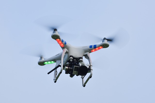 青空の下でドローンを飛ばす人々が笑顔で楽しんでいる様子
