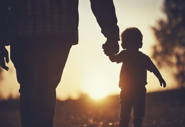 青空の下、家族が笑顔で手をつないでいる様子