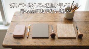 木製テーブルの上に彫刻前の消しゴム板・リノブロック・木版画用のシナベニヤ板を左から順に並べ、それぞれに彫刻刀やカッターナイフを添えた様子